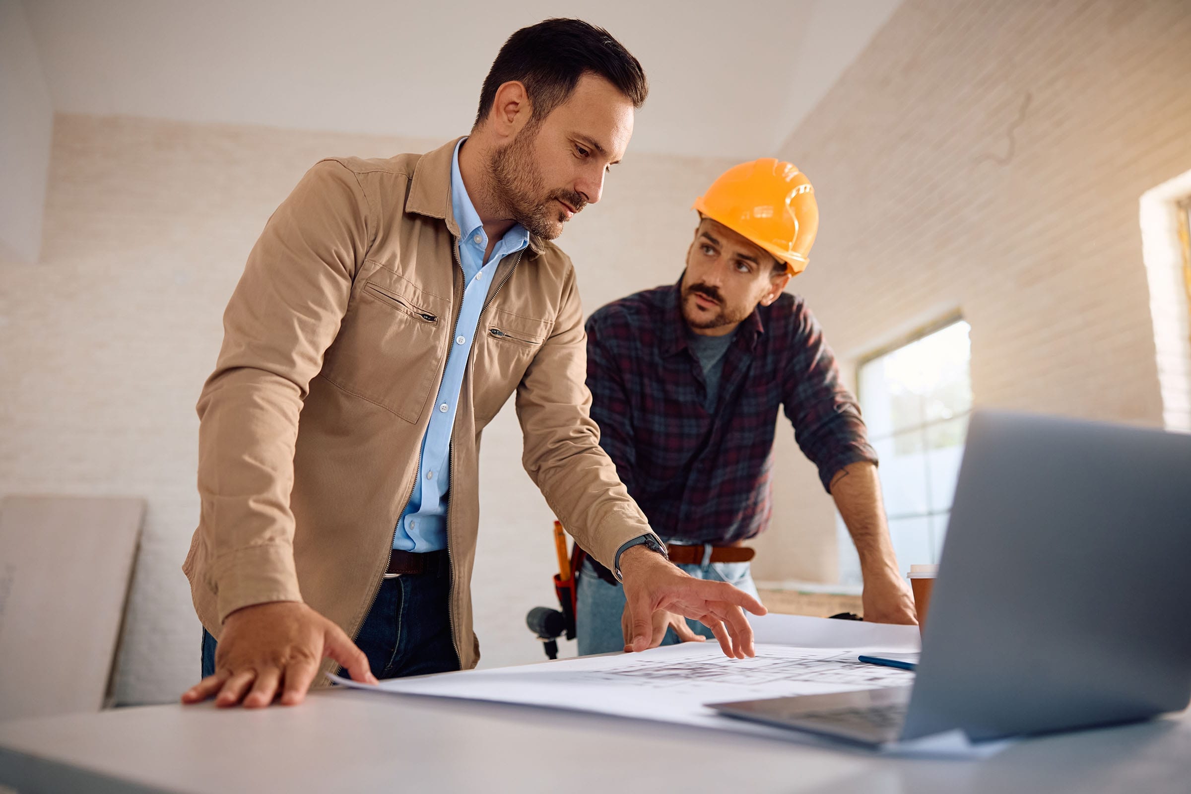 Architects reviewing building plans in office.